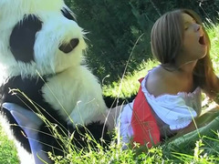 Guy in a panda suit is penetrating a busty woman in the field